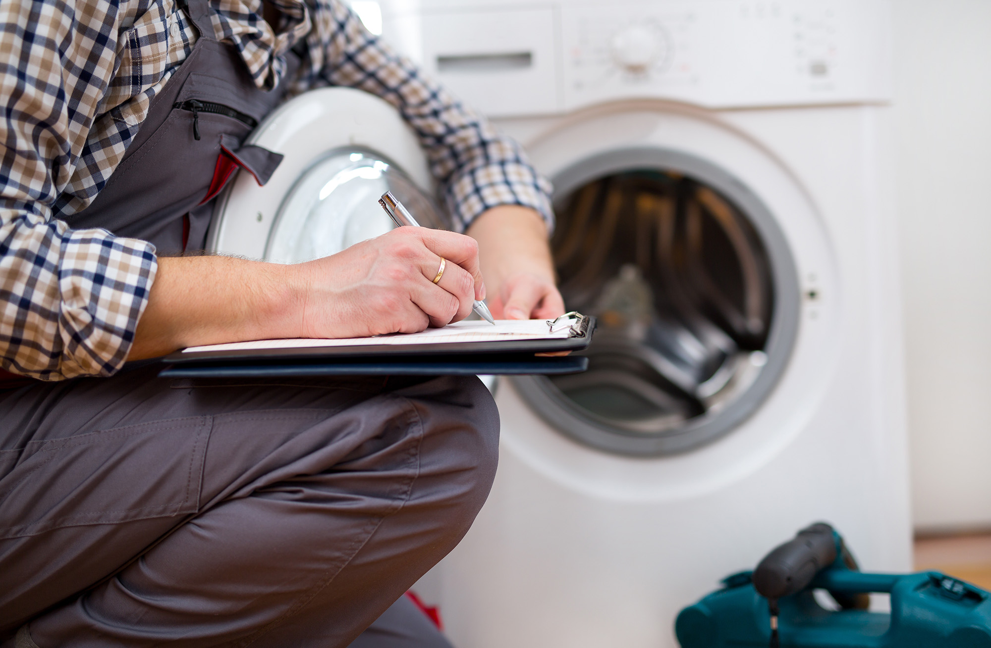 Repairman is repairing a dryer on a white background